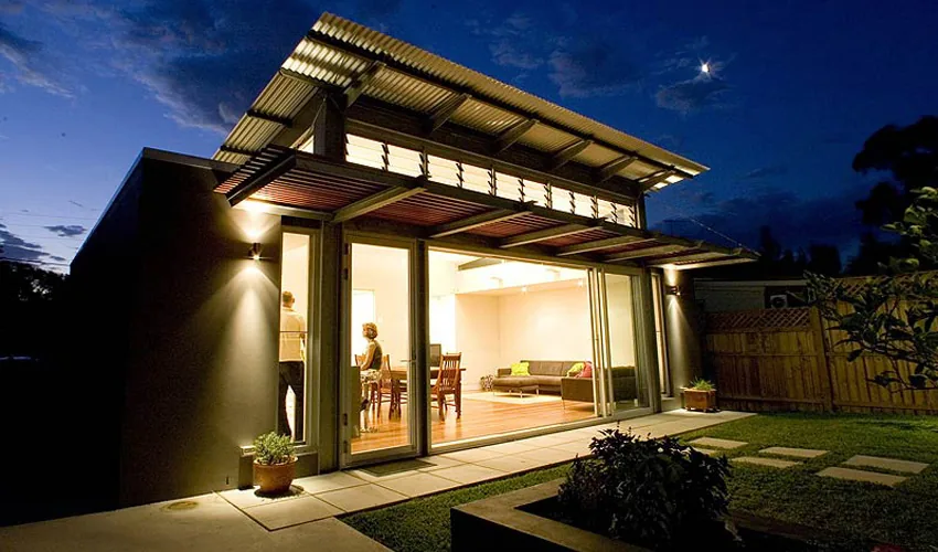 Timber and glass rear pavilion opening to the garden at dusk, Leichhardt